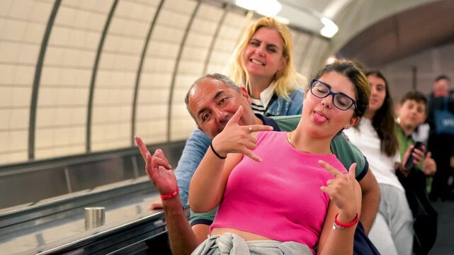 Caucasian family having fun riding down escalator in New York City subway station