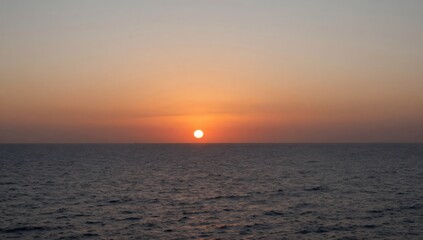 Obraz premium Warm sunrise reflecting on the tranquil ocean waves creates a scenic view