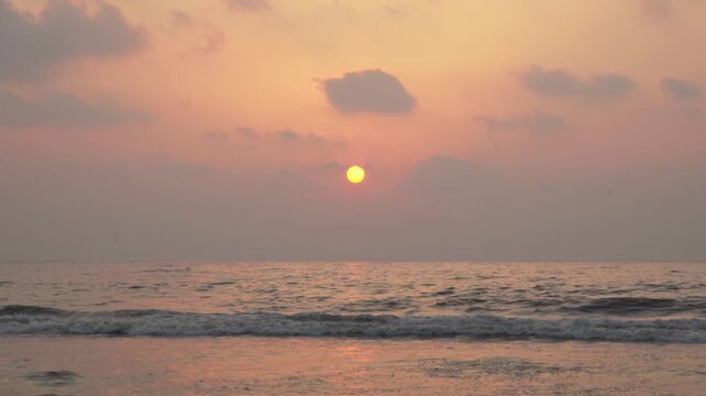 Stunning orange and pink morning sky over the sea with a glowing sun