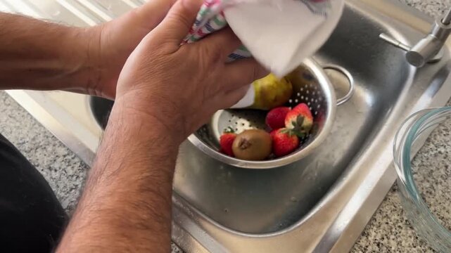 Manos secando un mango con un trapo de cocina