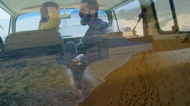 Beach overlay softening, woman adjusting hair and man gesturing in van, sharing travel memories