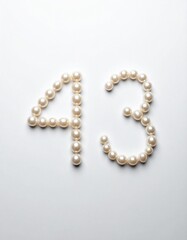 Obraz premium Number 43 made out of small pearls on a neutral solid background