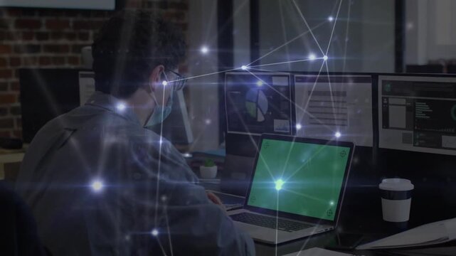 Masked dev typing on laptop causing neural nodes animating across office for AI demo