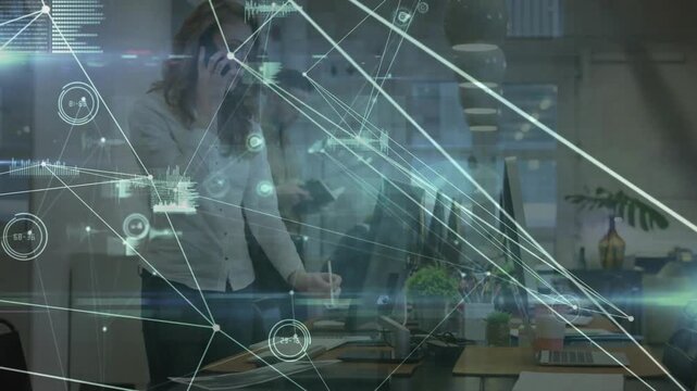 Worker approaching desk, sorting files, typing, calling as HUD graphics mapping data to manage work