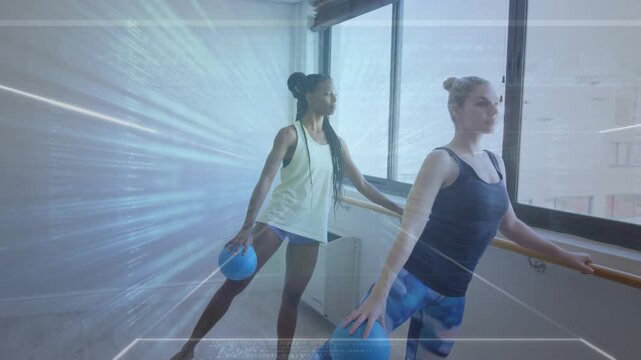 Two women shifting weight extending legs moving blue balls at barre with radial FX training fitness