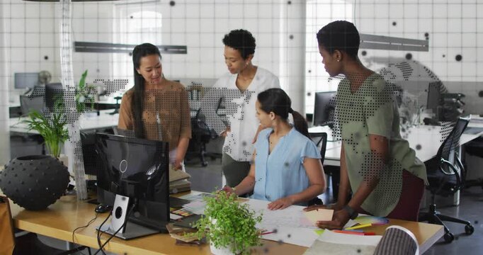 Woman pointing at monitor starting meeting, four women leaning in, consulting plans, finalizing