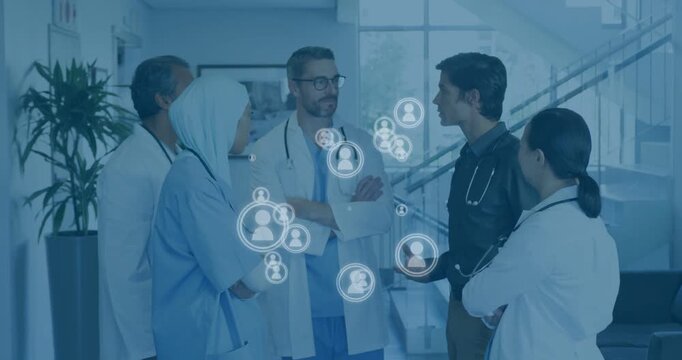Medical team standing in lobby, speaker gesturing and causing icons to appear, mapping care links