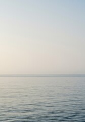 Obraz premium A vast, uninterrupted seascape where the calm ocean meets the pale, cloudless sky along a perfectly defined, empty horizon line, sky, freedom, expanse