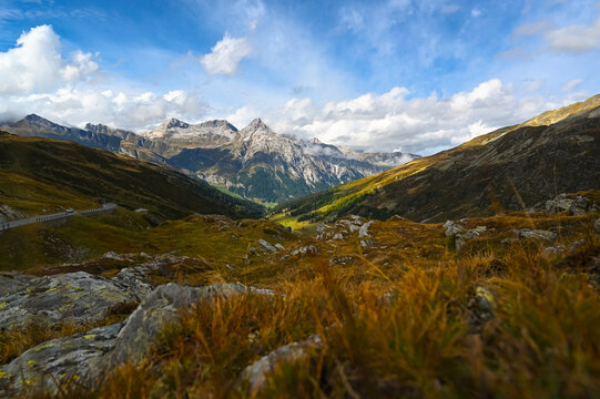 On the journey, a view from the Spl&uuml;gen Pass in the Alps, with the Via Spluga leading to the Teurihorn in Switzerland, featuring valleys, other peaks, and mountain panoramic scenery.