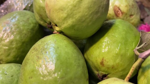 Fresh green organic guava fruits in a group at a local tropical market