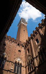 Obraz premium Upward view of Torre del Mangia from Palazzo Pubblico courtyard