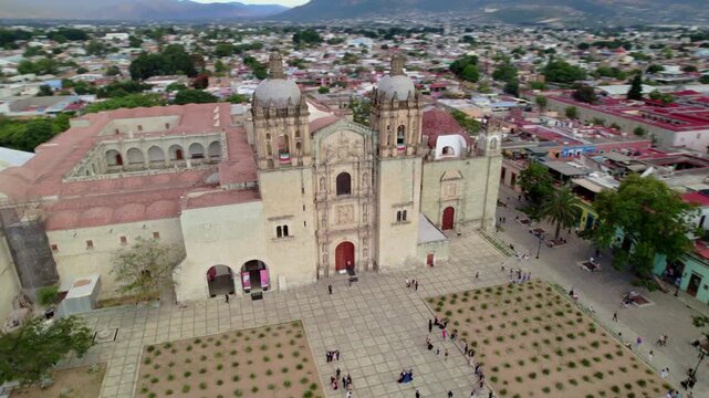 Vuelo de drone en Templo de Santo Domingo de Guzm&aacute;n, Oaxaca: Movimiento Dolly In lateral destacando la fachada de cantera verde, torres barrocas y plaza principal en M&eacute;xico.