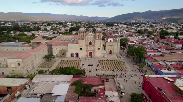 Vuelo de drone en Templo de Santo Domingo de Guzm&aacute;n, Oaxaca: Movimiento Dolly In lateral destacando la fachada de cantera verde, torres barrocas y plaza principal en M&eacute;xico.