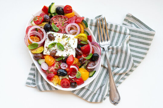 Greek salad with feta cheese and herbs. Greek bowl. Mediterranean cuisine and Greece. Healthy eating and recipes 