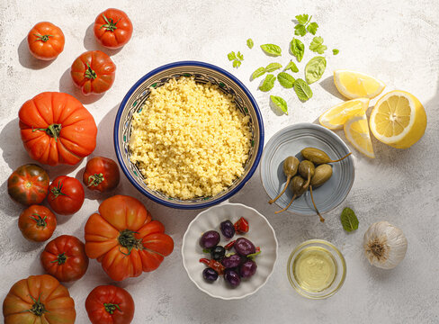 Ingredients for Tabbouleh o&nbsp;tabul&egrave; salad, Arab dish from the Middle East and Mediterranean, with parsley, bulgur, onions, mint and tomatoes, seasoned with lemon juice, olive and oil, capers 