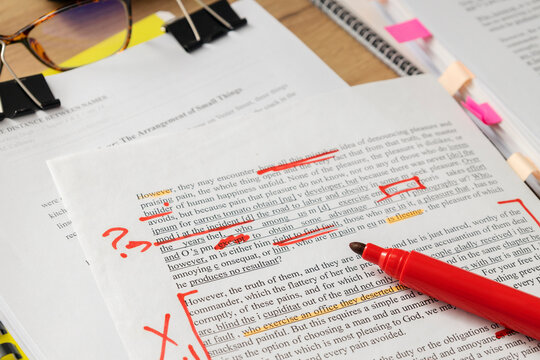 Detailed view of annotated pages and pen on desk illustrating professional document review and text correction