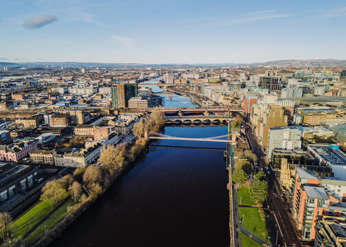 Glasgow Scotland: 13th Feb 2026: Caledonian Railway Bridge, King George V Bridge, Glasgow Bridge over River Clyde, with buildings lining the waterfront. Drone view golden hour with city skyline