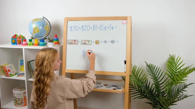 A child studies at home, practicing addition with dollar bills and coins on a magnetic board, combining homeschooling with financial education, filmed in 4K.