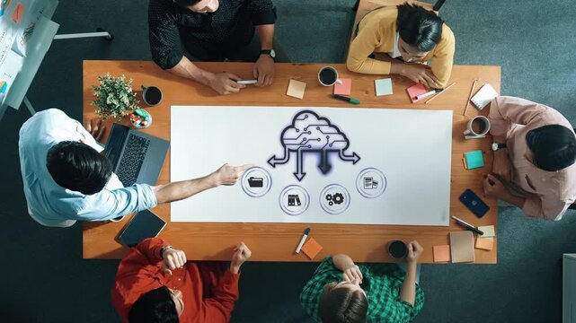 A diverse team engages in a brainstorming session, using visual aids and technology to foster collaboration and creative thinking in a modern office environment. Raster