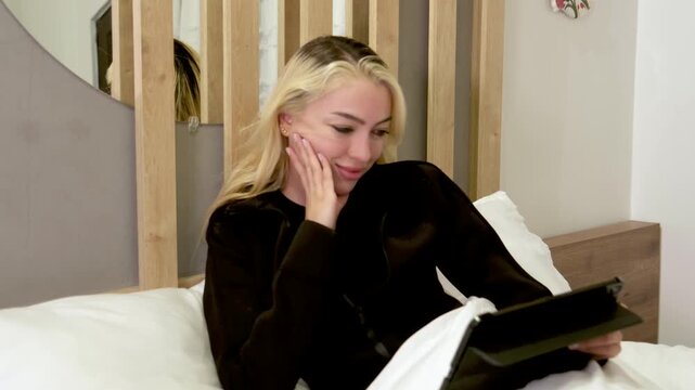 Blonde woman reading a book indoors in a cozy setting, resting her head thoughtfully while enjoying literature, calm and focused atmosphere with soft lighting, education and relaxation concept