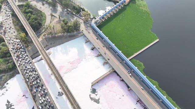 Aerial 4k view of Pollution in Yamuna River, Foam in river water and heavy traffic jam at Kalandi Kunj, Delhi, India