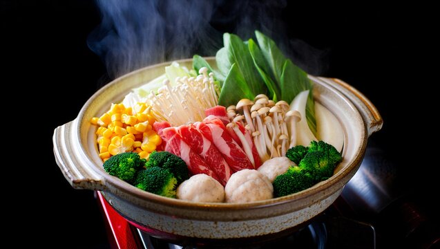 Japanese hot pot nabe cooking with beef and vegetables in ceramic bowl steaming soup delicious meal