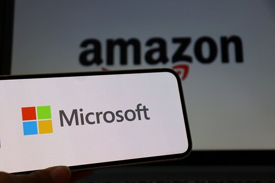 Salvador, Brazil - March 18, 2026: Microsoft logo displayed on smartphone screen with Amazon logo in the background. Concept of big tech. Microsoft and Amazon. 