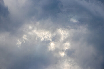 Fototapeta premium Dark storm clouds with glimpse of sunlight dramatic sky before rain atmospheric background natural light