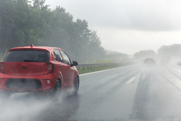 Fototapeta premium Back tail view of many cars driving fast on wet highway road after rain in Europe. Automobile accident vehicle rush hour collapse. Transportation vacation seasonal stuck. Low visibility bad weather