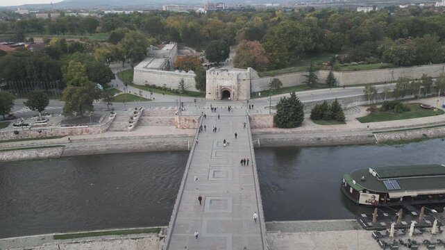 Aerial perspective of historic pedestrian bridge crossing Nisava river in central Nis, southern Serbia. Retreating drone video.