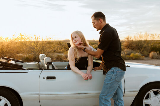 Loving couple in convertible in the desert