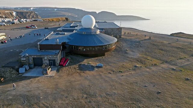 Drone aerial approaching the Nordkapp visitor centre with the radar dome building in northern Norway. Arctic tundra surrounds the famous North Cape destination.