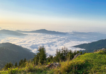 Fototapeta premium Breathtaking mountain landscape showing layers of hills emerging through morning mist and clouds