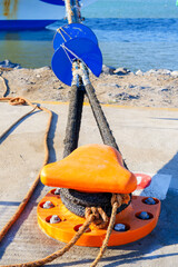 Fototapeta premium Orange Mooring Bollard with Heavy Duty Dock Lines at Port
