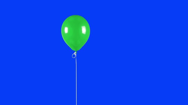 A bright green shiny balloon moves slightly on a string over a solid blue chroma key background. Perfect for projects where blue screen compositing is preferred over green.