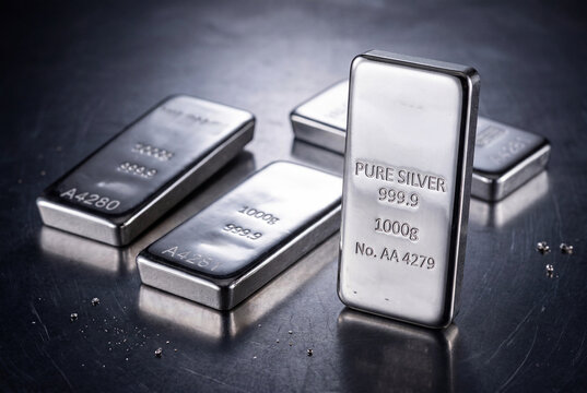 Gleaming 1000g silver bars scattered on dark metallic surface