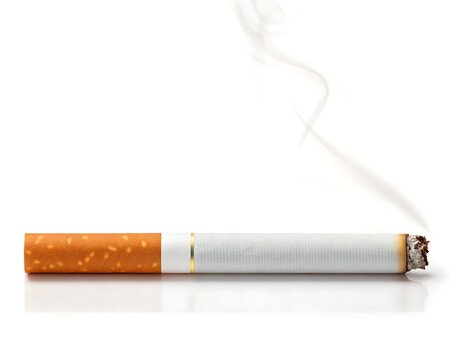 Smoking cigarette with ash emitting from the tip on a plain background