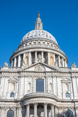Obraz premium St Pauls Cathedral is located in London, United Kingdom. The dome is visible and clearly shows architectural details. The sky is bright and clear, enhancing the view of the building.