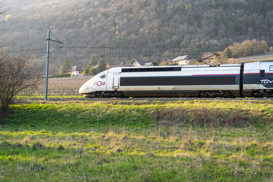 Savoie, France - March 7'2026 : A French TGV train running in a countryside of France at the fotot of mountain, surround with scenic landscape of nature with sunny day ambiance. 