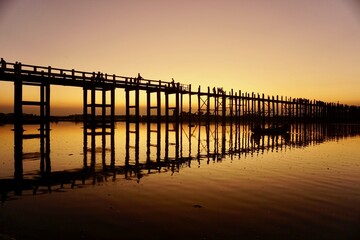 Obraz premium U-Bein Bridge at sunset with orange sky, iconic teak bridge in Myanmar
