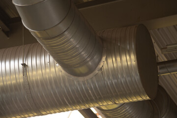 Metal ventilation duct system installed under ceiling in industrial interior