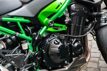 Obraz premium Selective focus on motorcycle frame. Closeup motorcycle exhaust pipe, engine guard, and foot rest. Motorcycle industry. Shiny new motorbike engine.