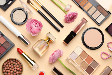 Fototapeta premium Spring composition with different makeup products and pink ranunculus flowers on beige background, flat lay