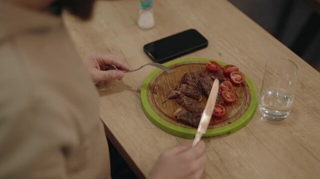 Person Enjoying a Delicious Grilled Steak with Fresh Cherry Tomatoes for a Healthy Meal