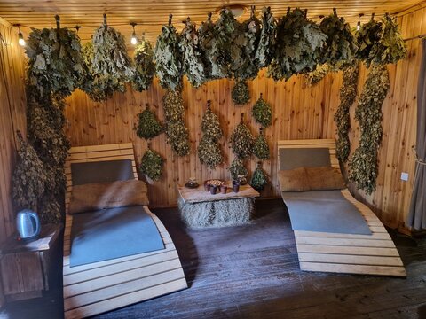 Traditional Eastern European banya interior with birch whisks, herbal tea and rustic wooden sauna setting