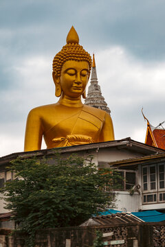 Giant Golden Buddha Statue at Wat Paknam Phasi Charoen Viewed from Canal in Bangkok	