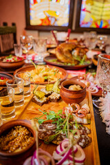 Fototapeta premium Colorful feast of traditional dishes and drinks displayed on a wooden table at a lively gathering