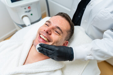 Man smiling during facial skincare treatment in clinic
