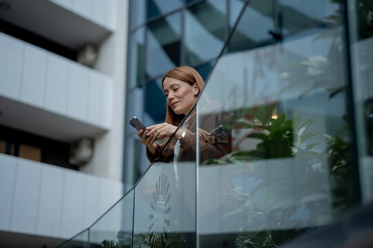 Professional woman communicating using smartphone in modern building