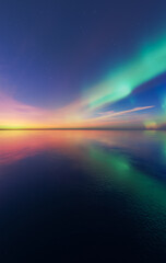 Fototapeta premium Northern Lights Aurora Over Calm Sea at Sunset With Colorful Sky and Reflection — 3D Rendering